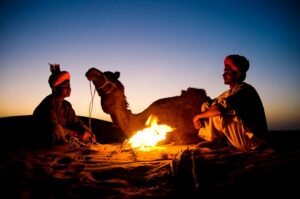 indian men resting by bonfire with their camel 53876 47057