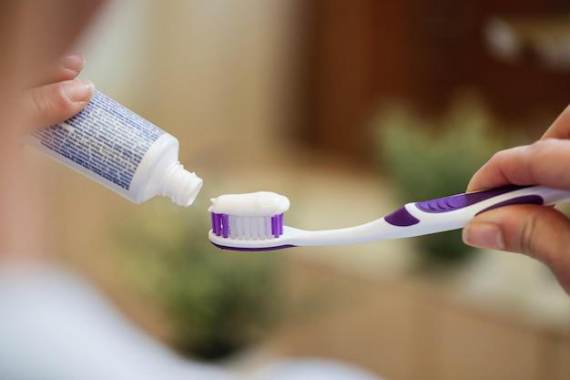 Woman applying toothpaste