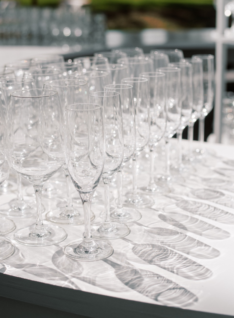 Wine glasses casting shadows on a white table at a Napa Valley wedding