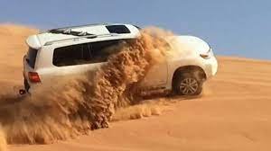 Luxury Hummer parked on golden sand dunes in Dubai during a VIP desert safari.