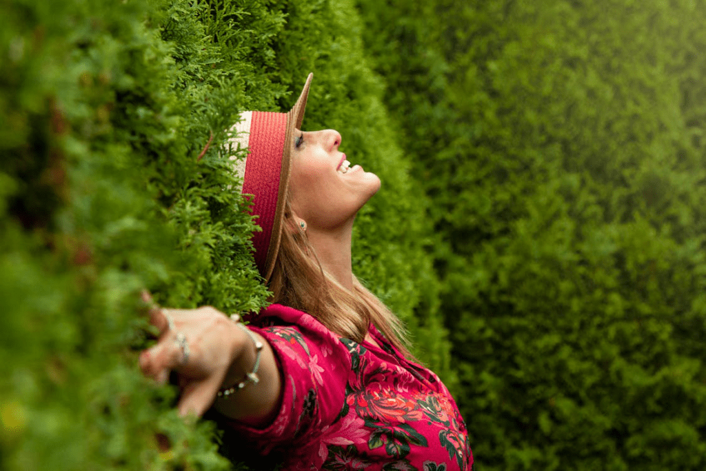 An image of a woman in pink dress and hat lying on the grass