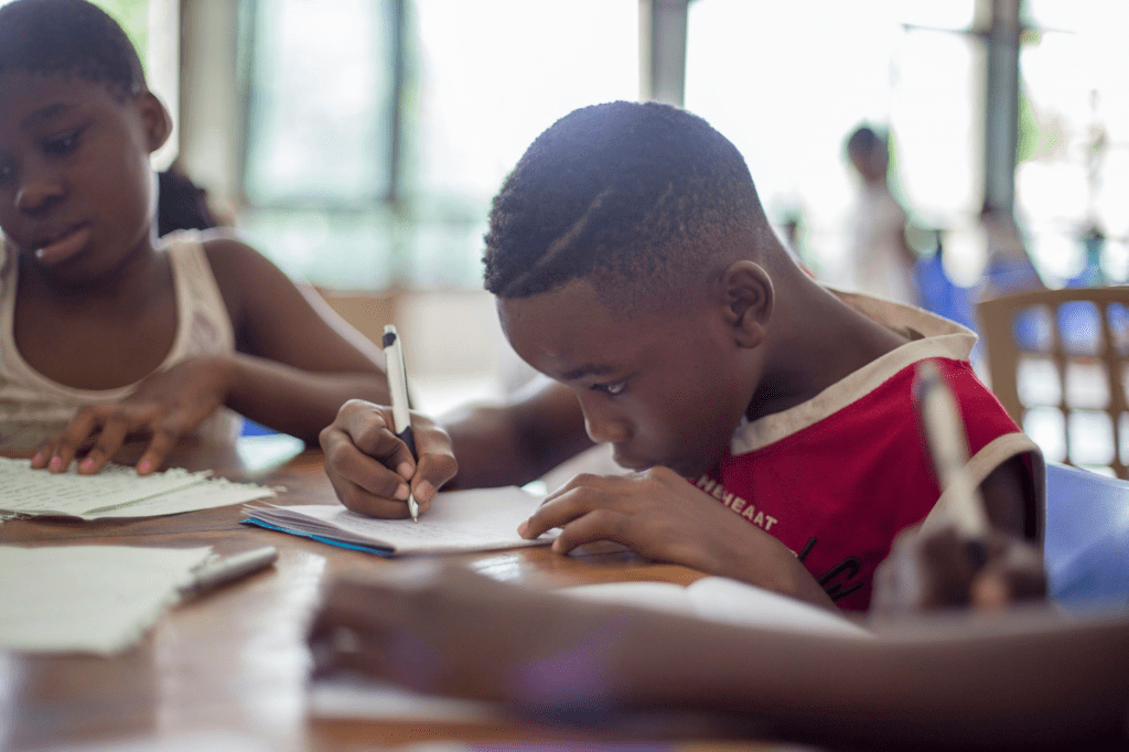 children writing something on paper