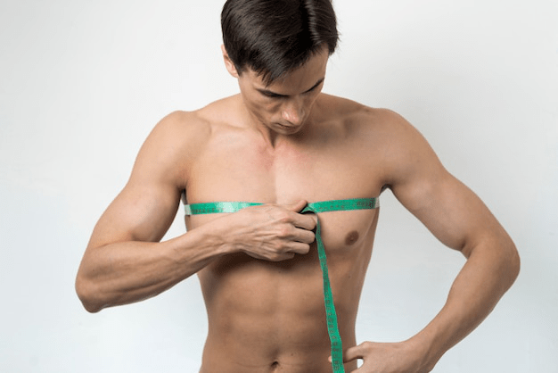 Man using a tape measure to check the size of his chest