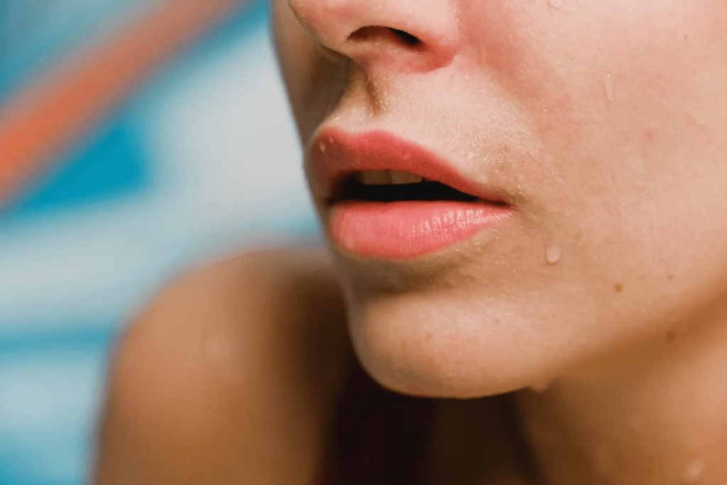 Close-up of water droplets on a person’s chin and lips